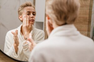 Jeune femme s'appliquant de la crème anti age de l'oreal