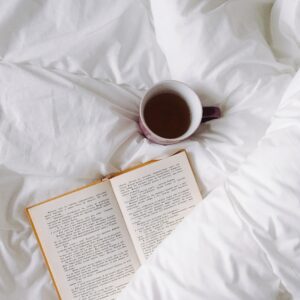 Tasse de café et livre sur des draps