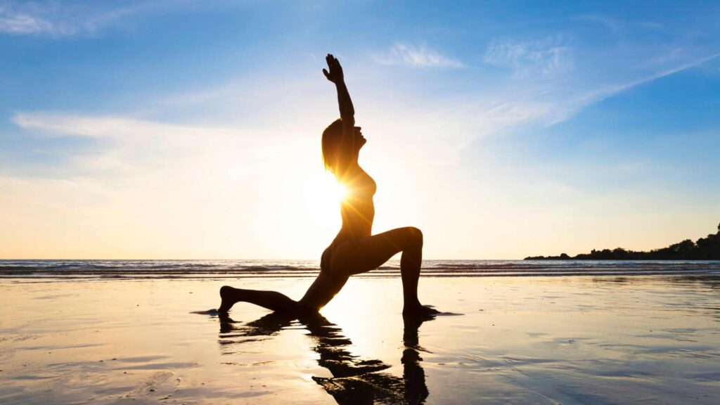 femme qui fait du yoga sur la plage